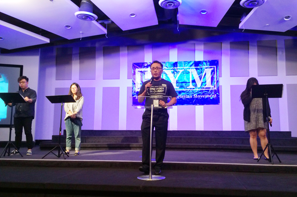 HYM이 남가주사랑의교회 킹덤드림센터에서 제33회 집회를 열었다. 더글라스 김 대표가 기도를 인도하고 있다.