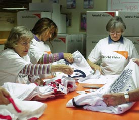 피츠버그에 있는 월드비전 물품 기증센터에서 직원들이 MLB로 부터 받은 기념의류를 분류하고 있다