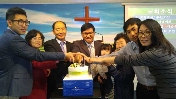 가장 어린 유아로부터 청년회장, 남녀선교회장, 교역자가 대표로 나와 기념 케익을 커팅하고 있다. (정중앙) 담임 강양규 목사.